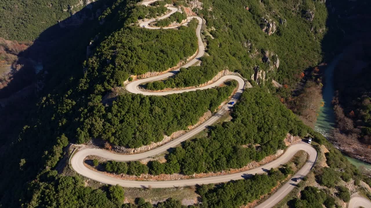 Dronebilde av biler som navigerer et fjellpass om høsten, Hellas