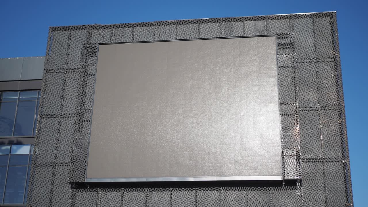 una gran pantalla de led en blanco en una fachada de edificio moderno