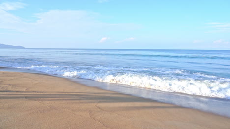 slow-motion of waves washing up on a golden sand beach