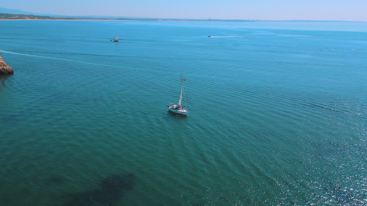 포르투갈 알가르베 의 프라야 도나 아나 에서 여름 에 바다 에 있는 요트 보트, 공중 드론 전망