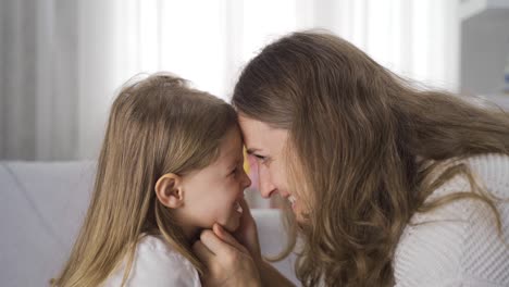 una madre mostrando amor a su hija pequeña.