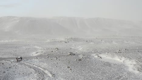 一辆越野车辆在冰川附近的冰岛荒野中在暴风雪中穿过公路