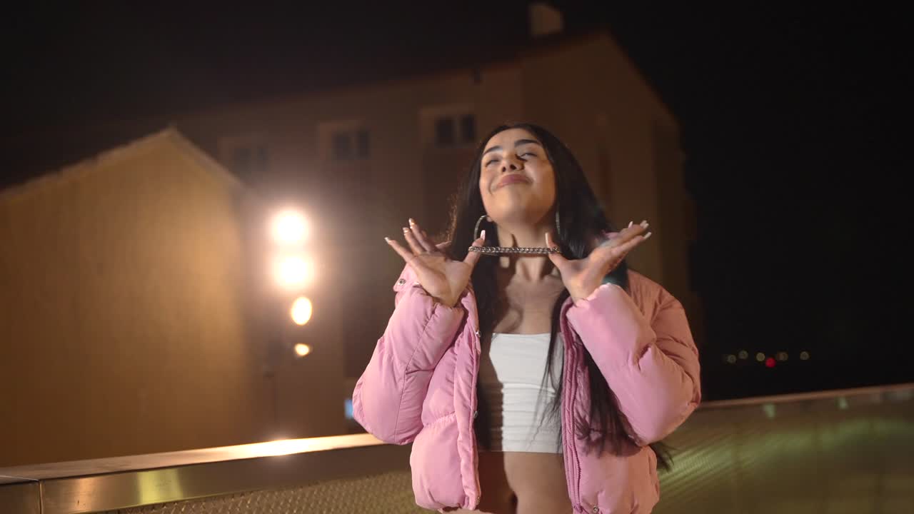 Woman in a pink puffer jacket at night