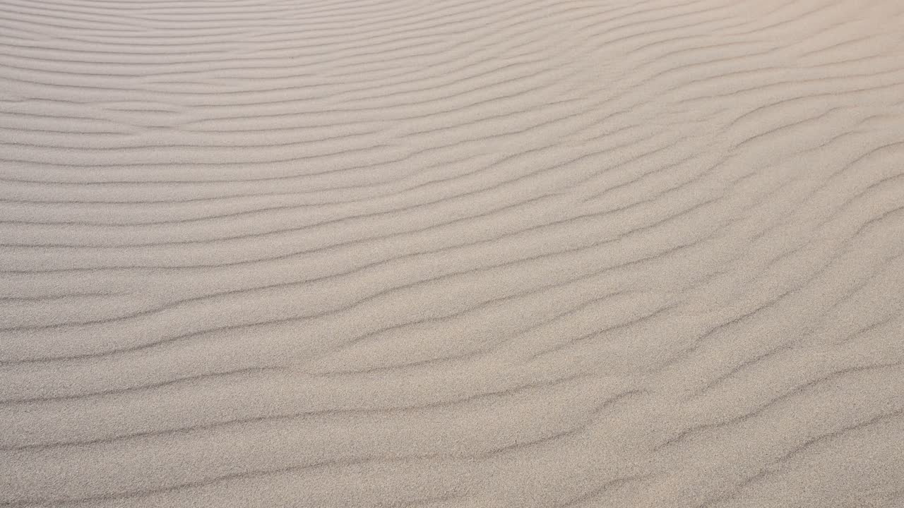 Natural patterns created by wind on the sand dunes of Durgun Nuur, Mongolia. A detailed shot of the desert's texture and serene beauty