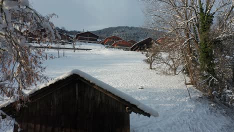 Jib-up-of-small-wooden-shed-covered-in-snow-near-a-small-town