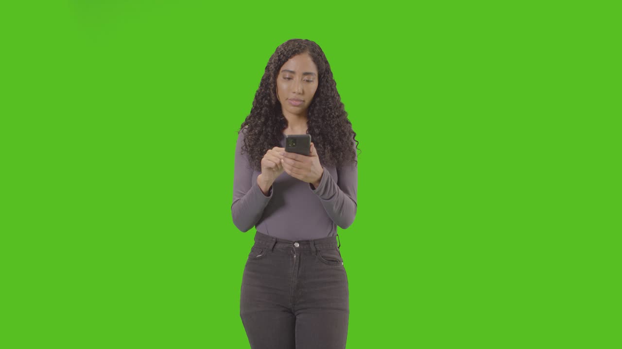 Woman Looking At Mobile Phone And Celebrating Good News Against Green Screen 4
