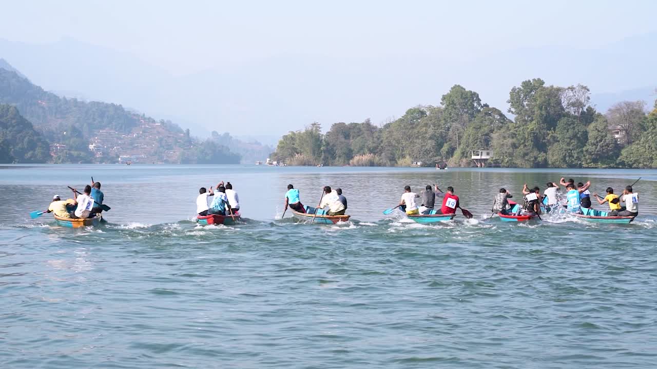 Slow-motion of people competeting in a boat race at Fewa Lake