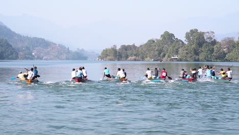 slow-motion of people competeting in a boat race at fewa lake