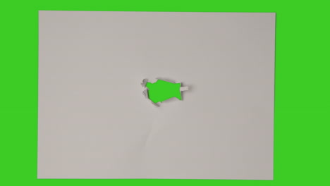 stop motion sequence of hole being torn in centre of sheet of paper on top of green screen background