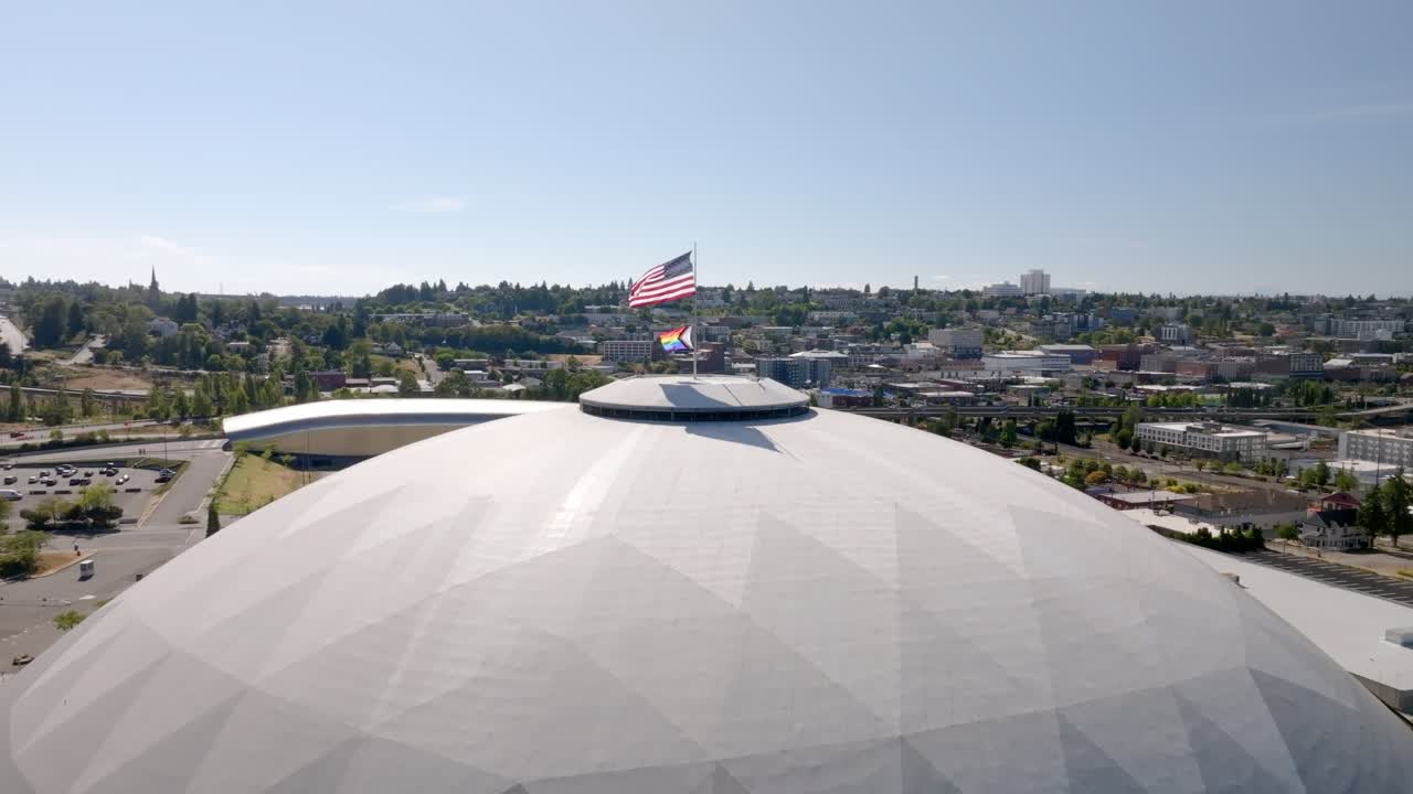 American And Pride Flag Raised On Top Of Tacoma Dome During Pride Festival In Washington, USA. - aerial shot