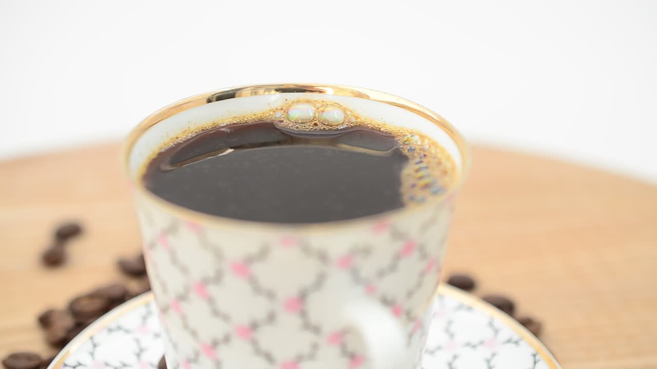 Caffè, tazza di caffè e chicchi. Ripresa in movimento