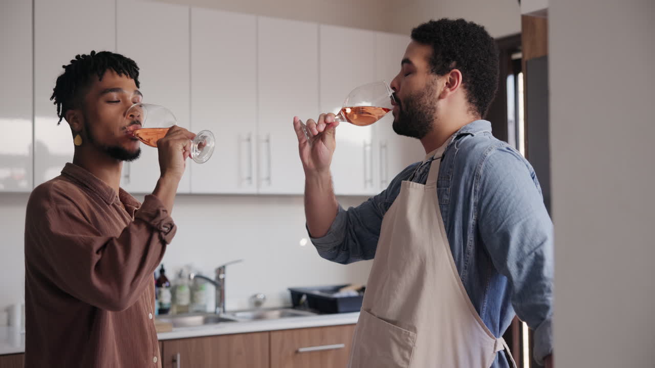 Amigos celebrando con vino rosado en la cocina
