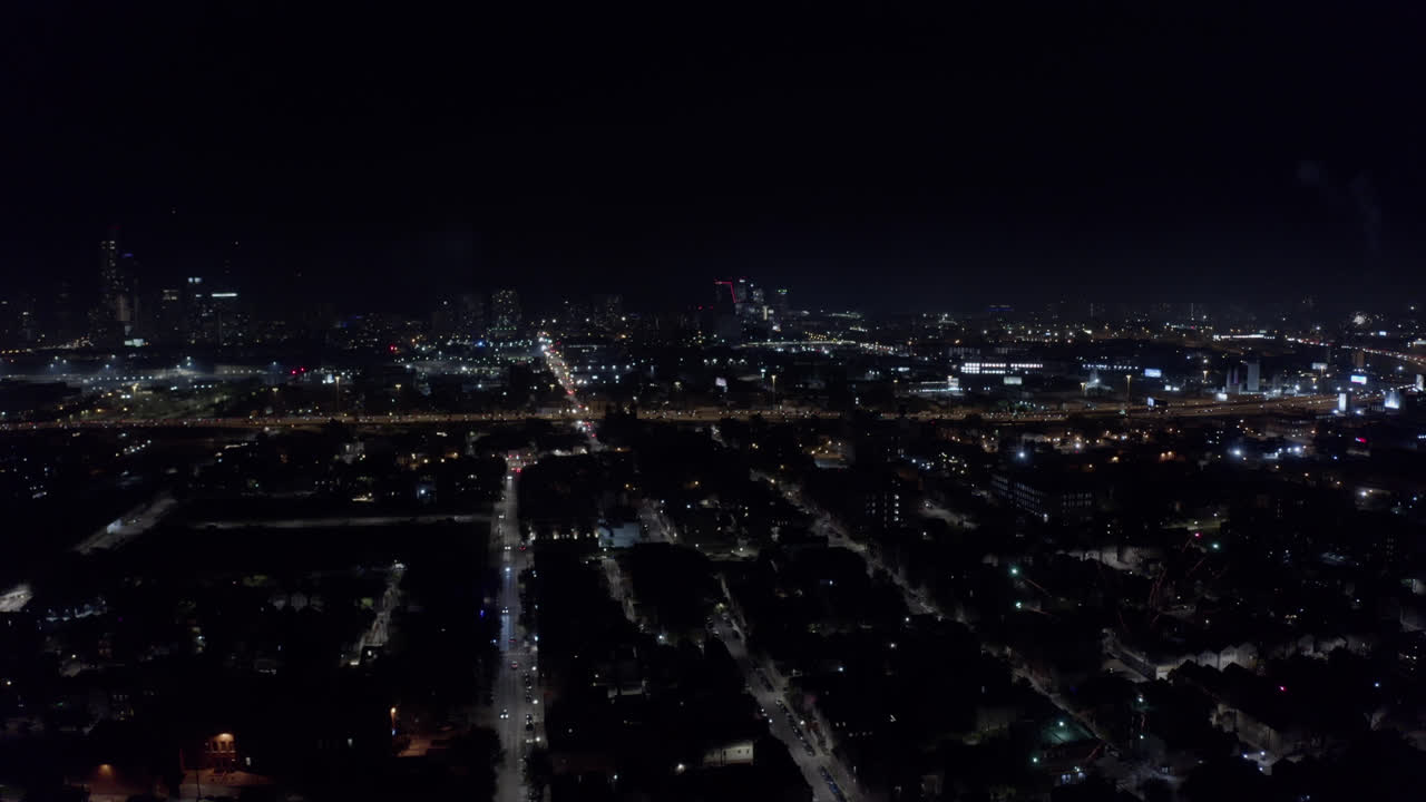 여러 대의 자동차가 분주한 고속도로를 달리는 독립기념일 때문에 시카고의 주거 지역에서 시작된 조명탄에서 밤에 큰 빛이 번쩍입니다.