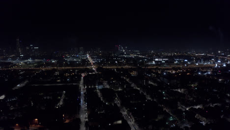 Large-flashes-of-light-in-the-night-from-flares-set-off-in-a-residential-area-in-Chicago-because-of-Independence-Day-as-several-cars-drive-on-a-busy-highway