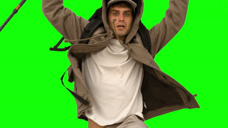 Man-with-a-hiking-stick-jumping-on-green-screen