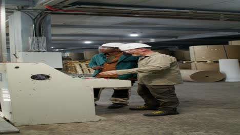 factory workers inspecting machinery