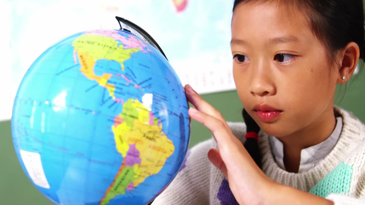 학교에서 교실에서 지구를 보는 여학생