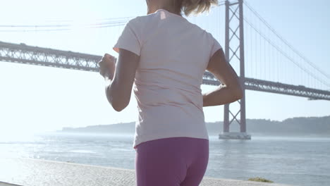 back view of blonde woman running during sunny day