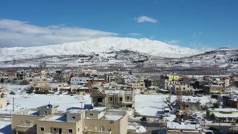 布卡塔市的白色雪在彩色的房子与赫蒙山在背景在一个明亮的阳光明<unk>的日子