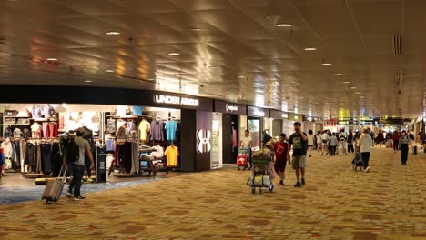 people walking and shopping in airport terminal