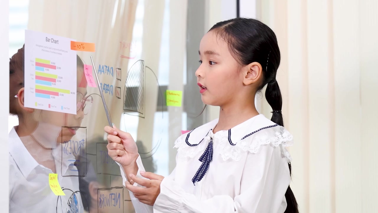 ガラスボードでデータを説明する若いアジア人の女の子