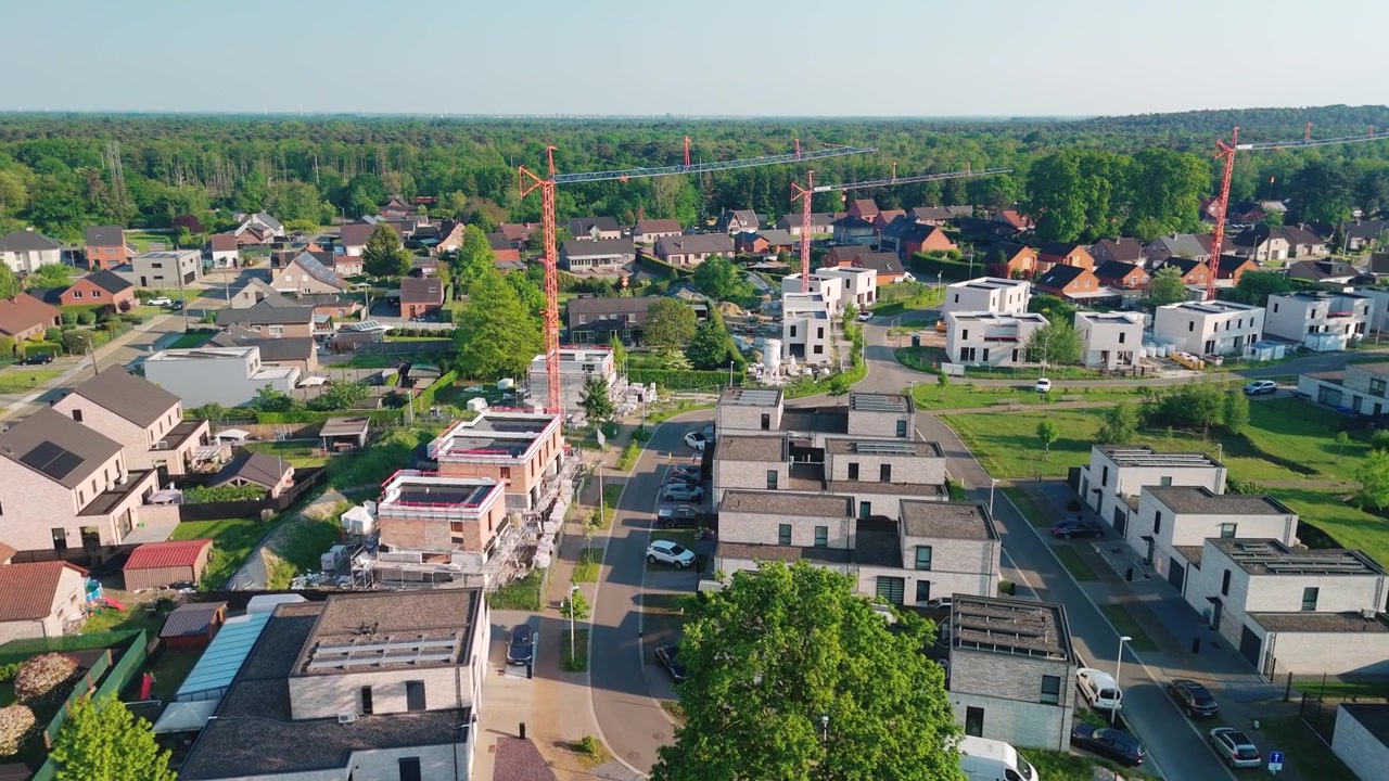 Luchtfoto boven een nieuwe woonwijk met stedelijke ontwikkeling, appartementenbouw op het platteland van België.