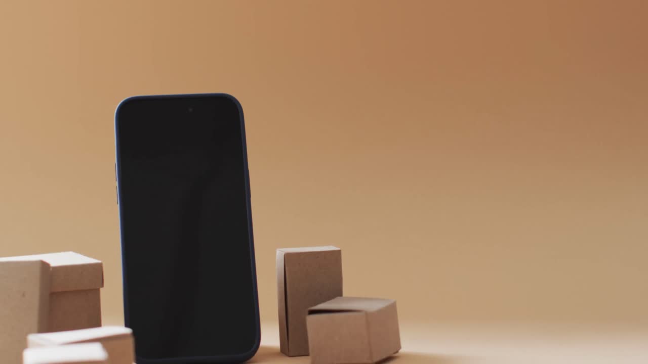 오렌지색 배경에 빈 화면과 복사 공간이 있는 상자의 스마트폰 비디오