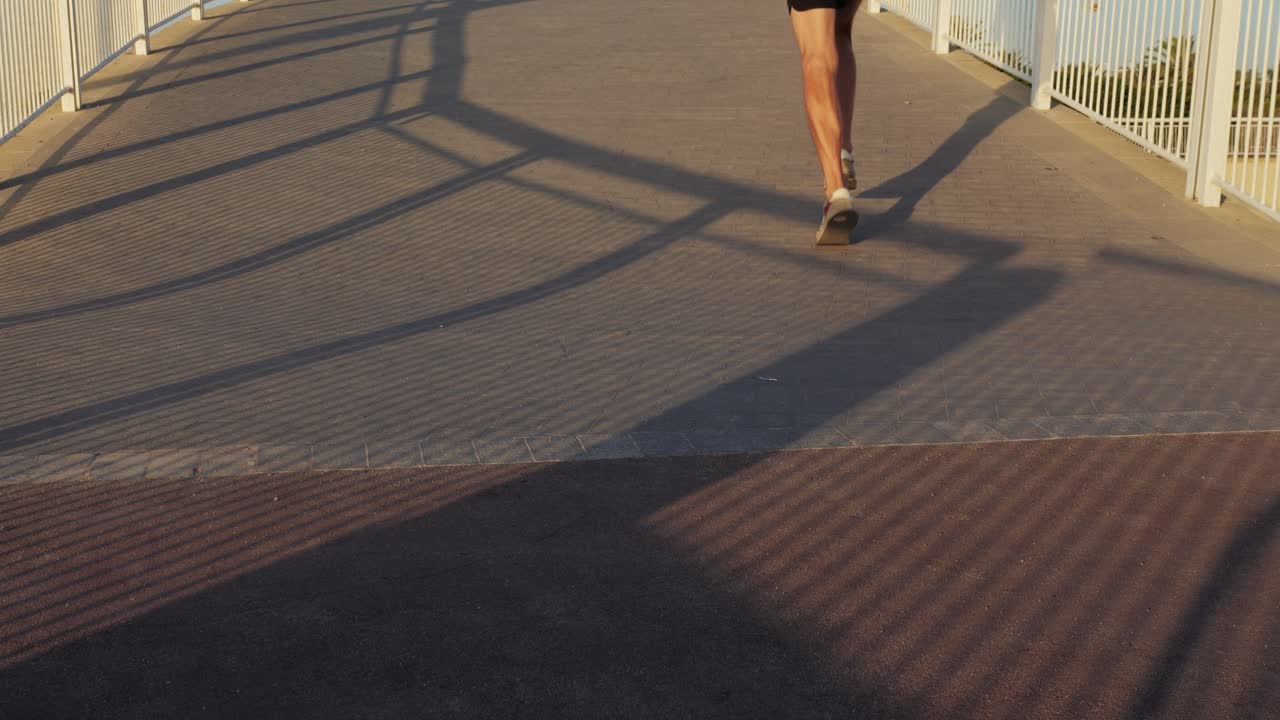 Person Walking/Running on a Bridge at Sunset