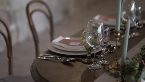 close up of a wedding table setting with glassware, plates, and candles, exuding elegance