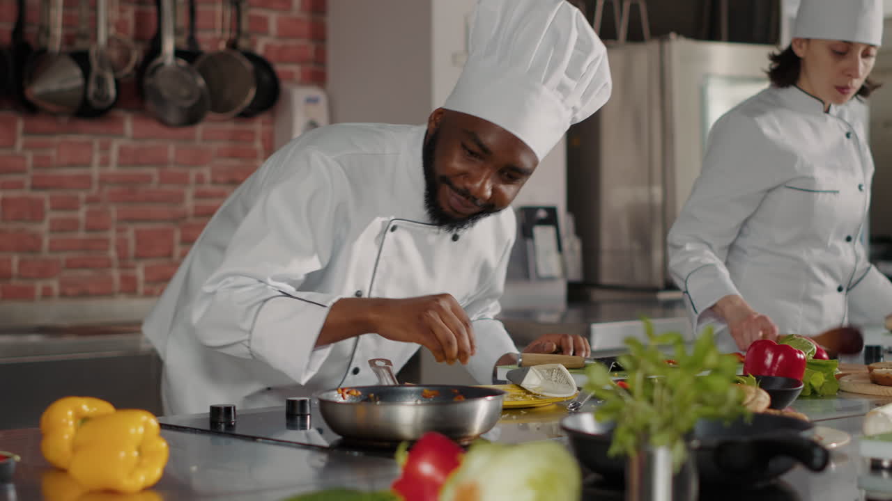 African american chef pouring shredded cheese in frying pan