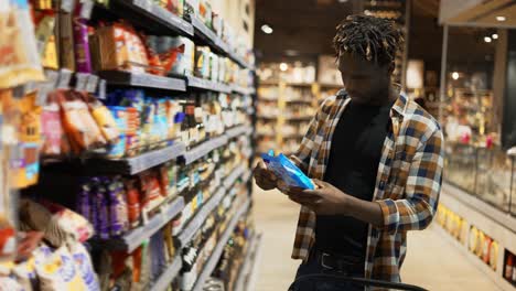 african american guy looking for products in the grocery store