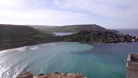 pequeña ruina situada en un acantilado con vistas a una playa en malta, que ofrece vistas panorámicas