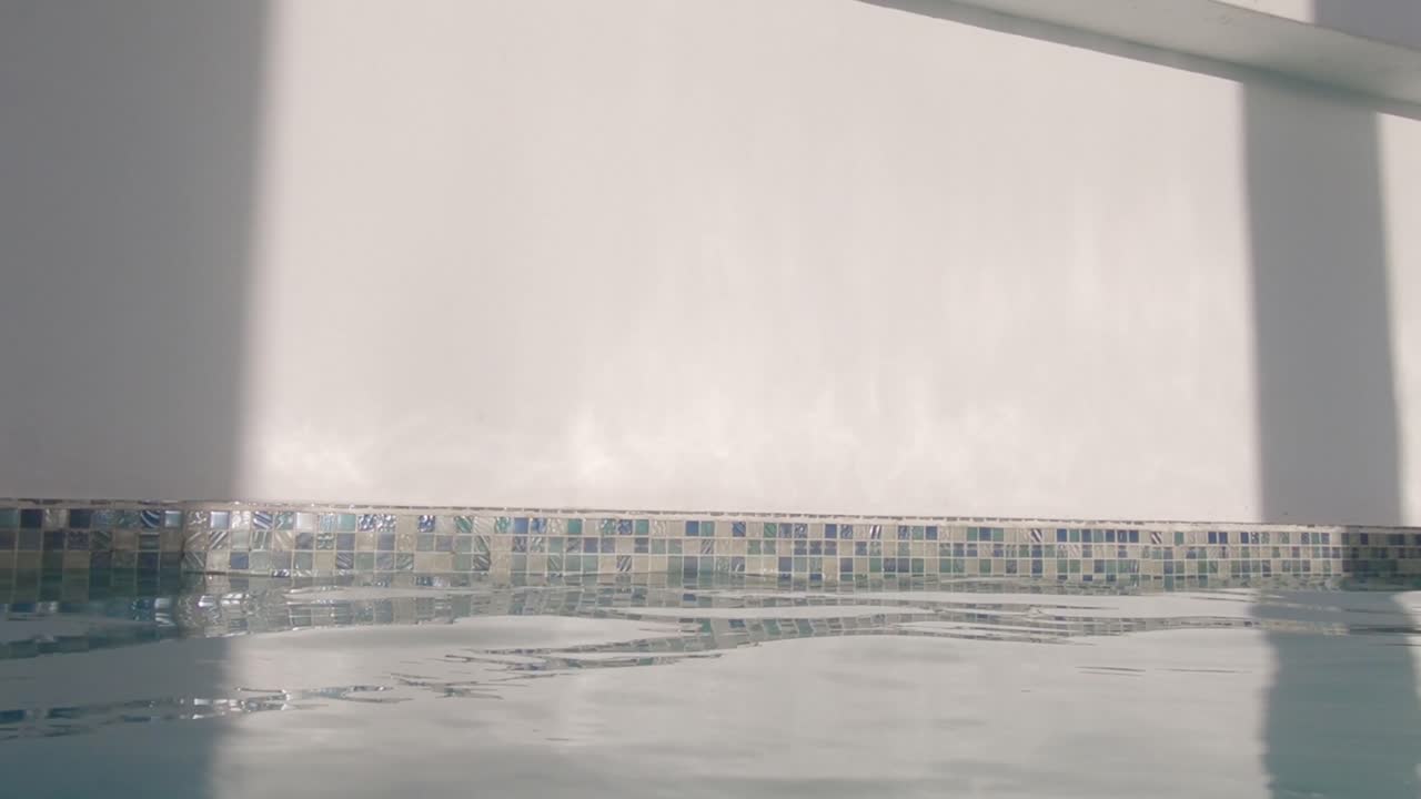 shot of a white wall in a public swimming pool, radiant sun in the caribbean