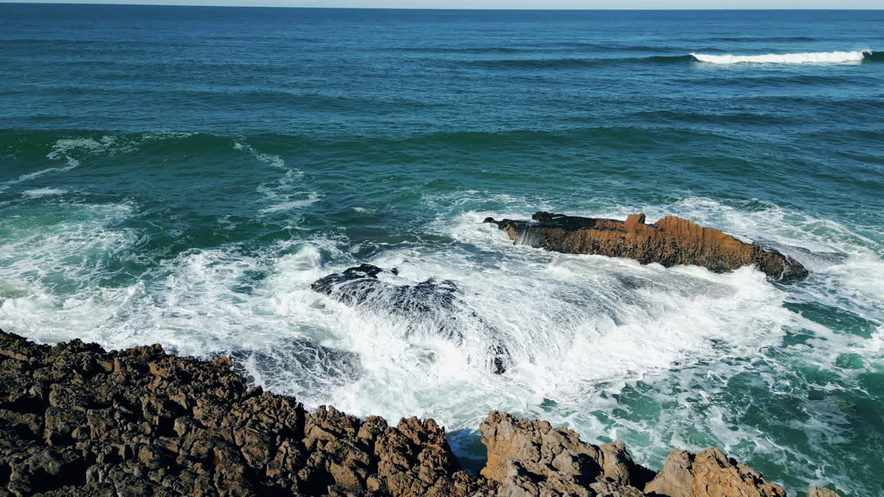 hermosa costa rocosa soleada vista aérea cinematográfica. las olas del mar chocando contra los acantilados.