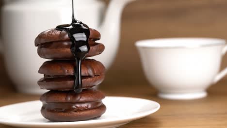 pouring chocolate syrup onto stack of choco pie.