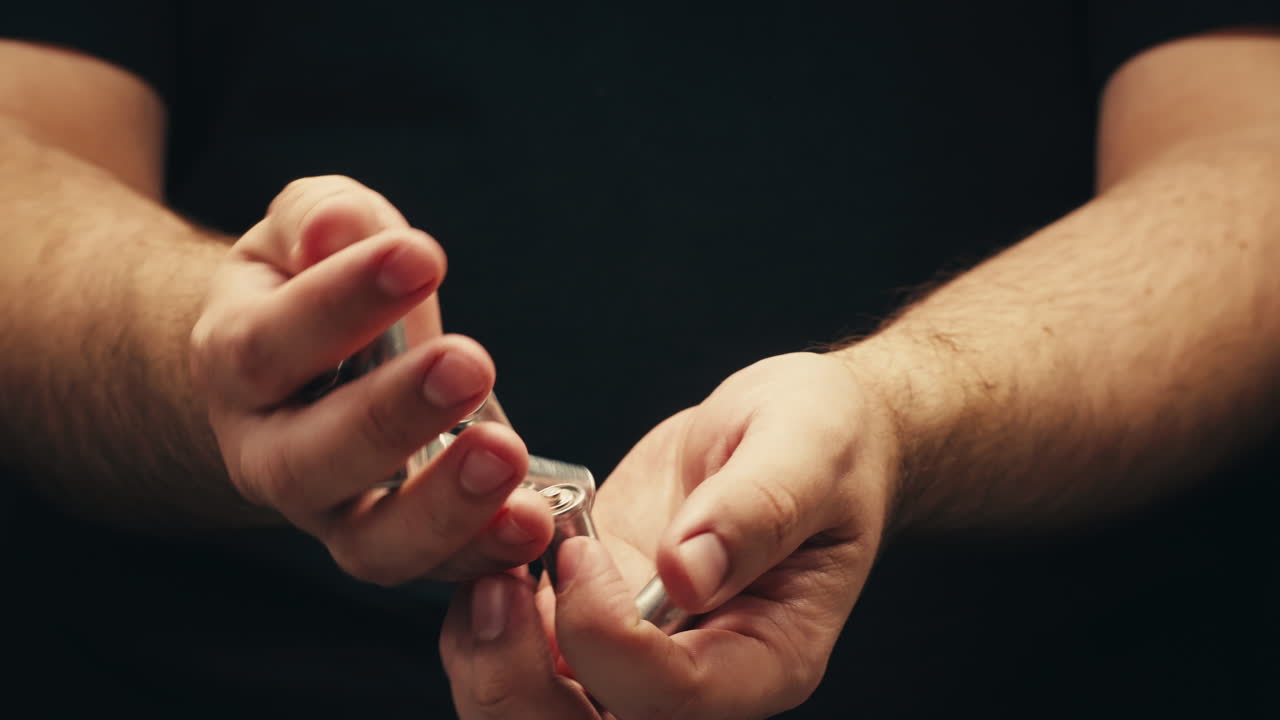 Silver batteries AA and AAA in hands on black background close-up. Double-A battery is a standard size single cell cylindrical dry battery. Batteries are common in portable electronic devices. An AA battery is composed of a single electrochemical cell that may be either a primary battery or a rechar