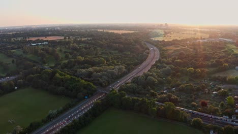 Follow-drone-shot-of-London-Underground-Piccadilly-Line-train-at-sunset