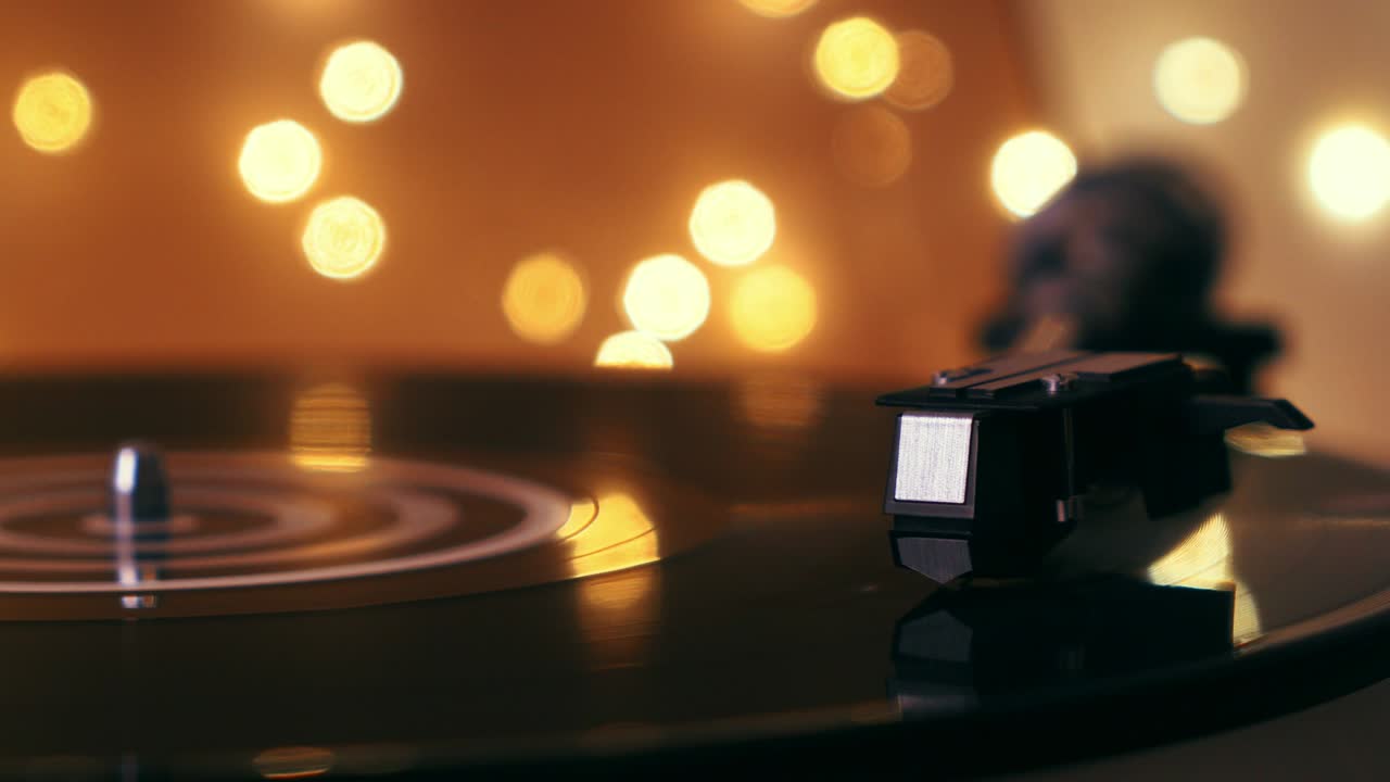 턴테이블 비닐 레코드 플레이어: 초점에서 디포커스: 가운 배경에서 그라모폰과 토크 플레이트 클로즈업; 밝은 보케를 배경으로 바늘 클로즈업을 가진 스타일러