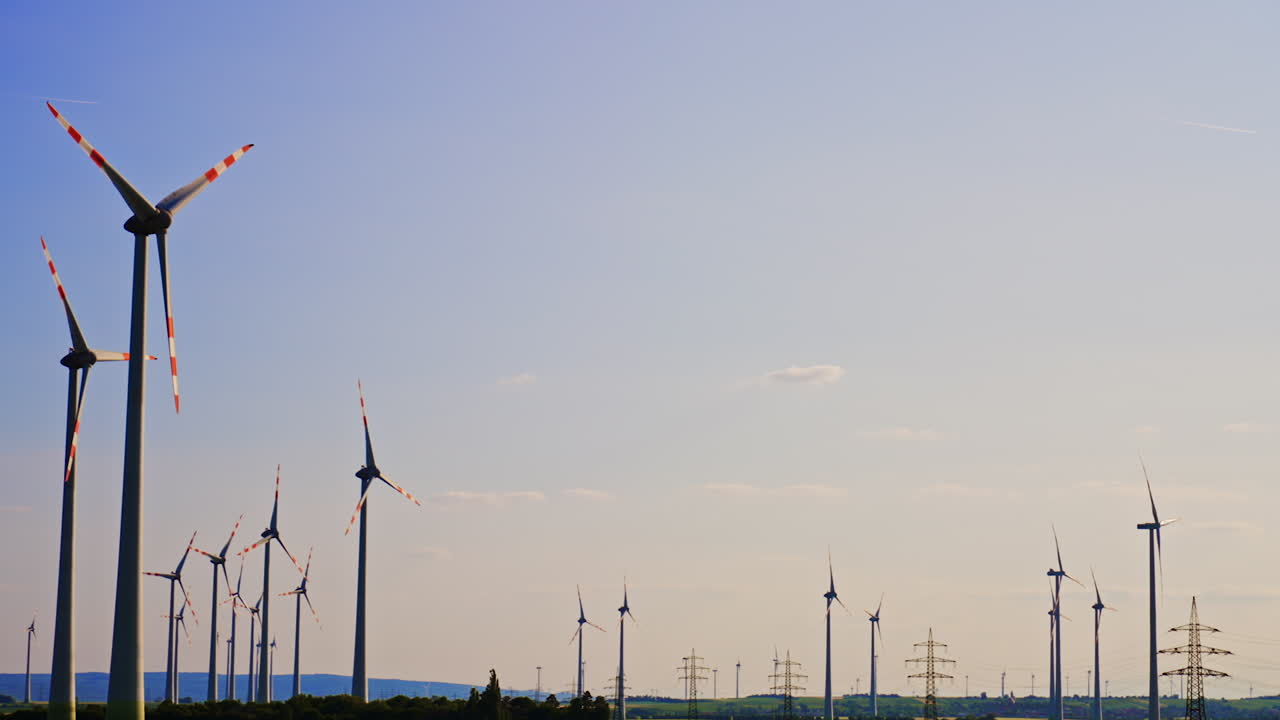 Wind turbines create outdoor energy. Wind turbines stand tall against a clear sky, showcasing renewable energy production in an expansive landscape
