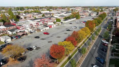 Aerial-establishing-show-above-urban-city-rowhomes-during-autumn,-colorful-trees