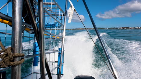 El-Barco-De-Buceo-En-Jaula-De-Tiburones-Sale-Al-Mar---Vista-Hacia-Atrás-De-La-Jaula-De-Tiburones-Y-La-Estela