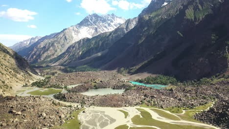 aerial shot of the mountains valley and turquoise waters at naltar valley in pakistan, wide drone shot flying towards the ground