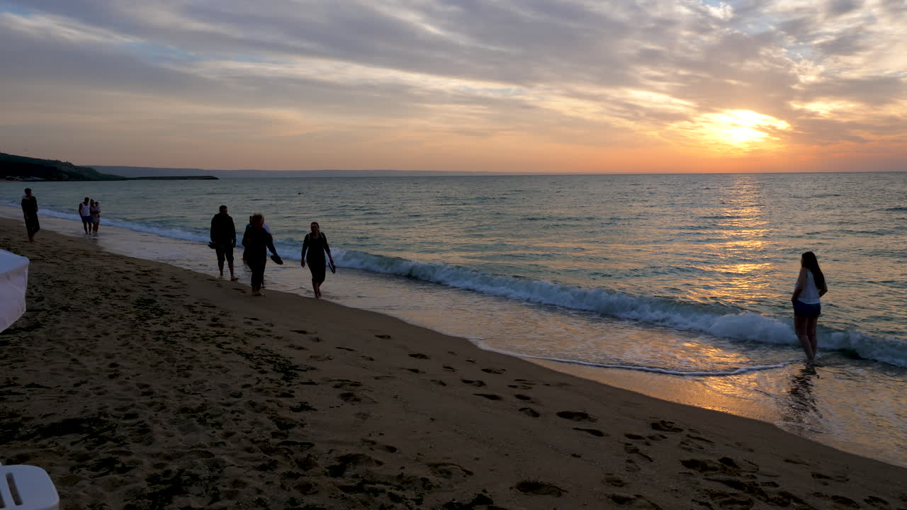People silhouette walking on the beach