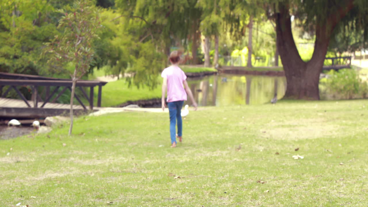 잔디 위를 고 있는 행복한 어린 소녀