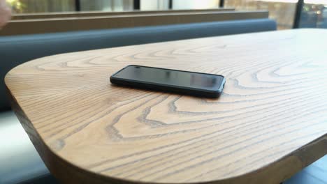 person using a smartphone at a cafe table