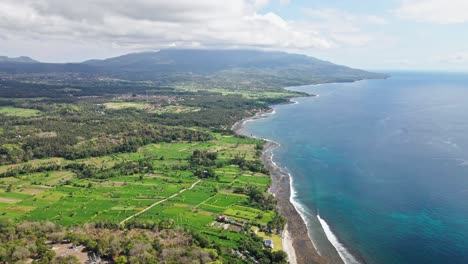 Drone-scene-of-the-cost-in-eastern-Bali-with-volcano-at-the-background-surrounded-by-the-ocean