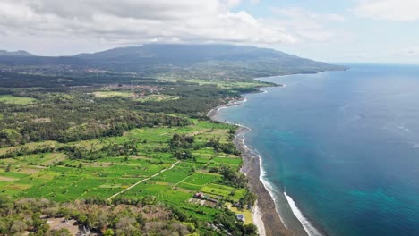 drone scene of the cost in eastern bali with volcano at the background surrounded by the ocean