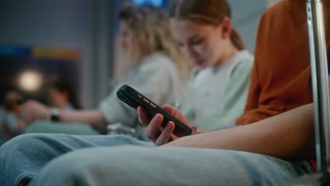 people waiting in a waiting room, using phones