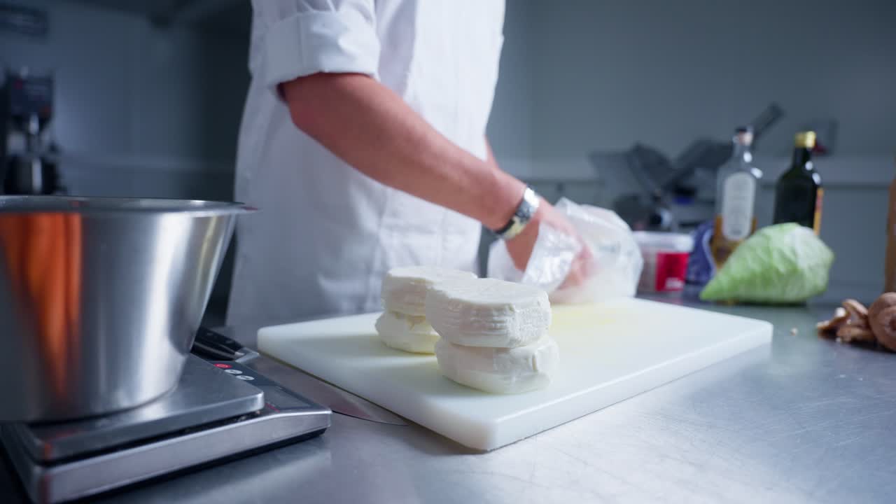 a chef taking feta cheese out of the wrapper