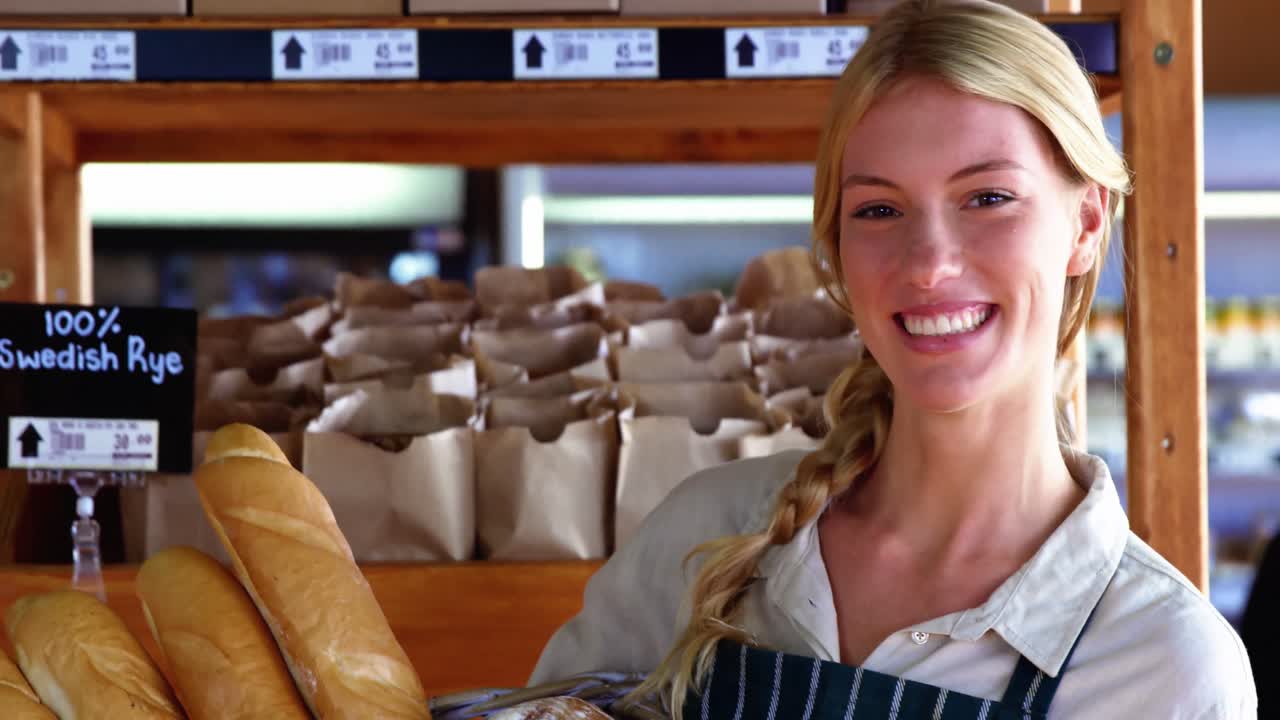 Canestro sorridente della tenuta del personale femminile di pane al contatore del pane